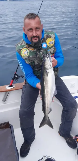 Angelgast mit großem Fisch an Bord des Boots
